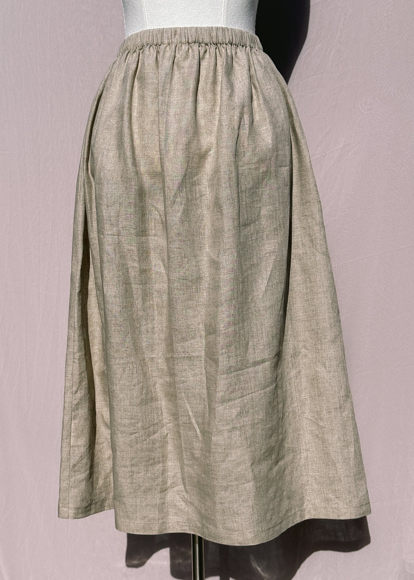 Beige linen skirt on a mannequin against a plain background