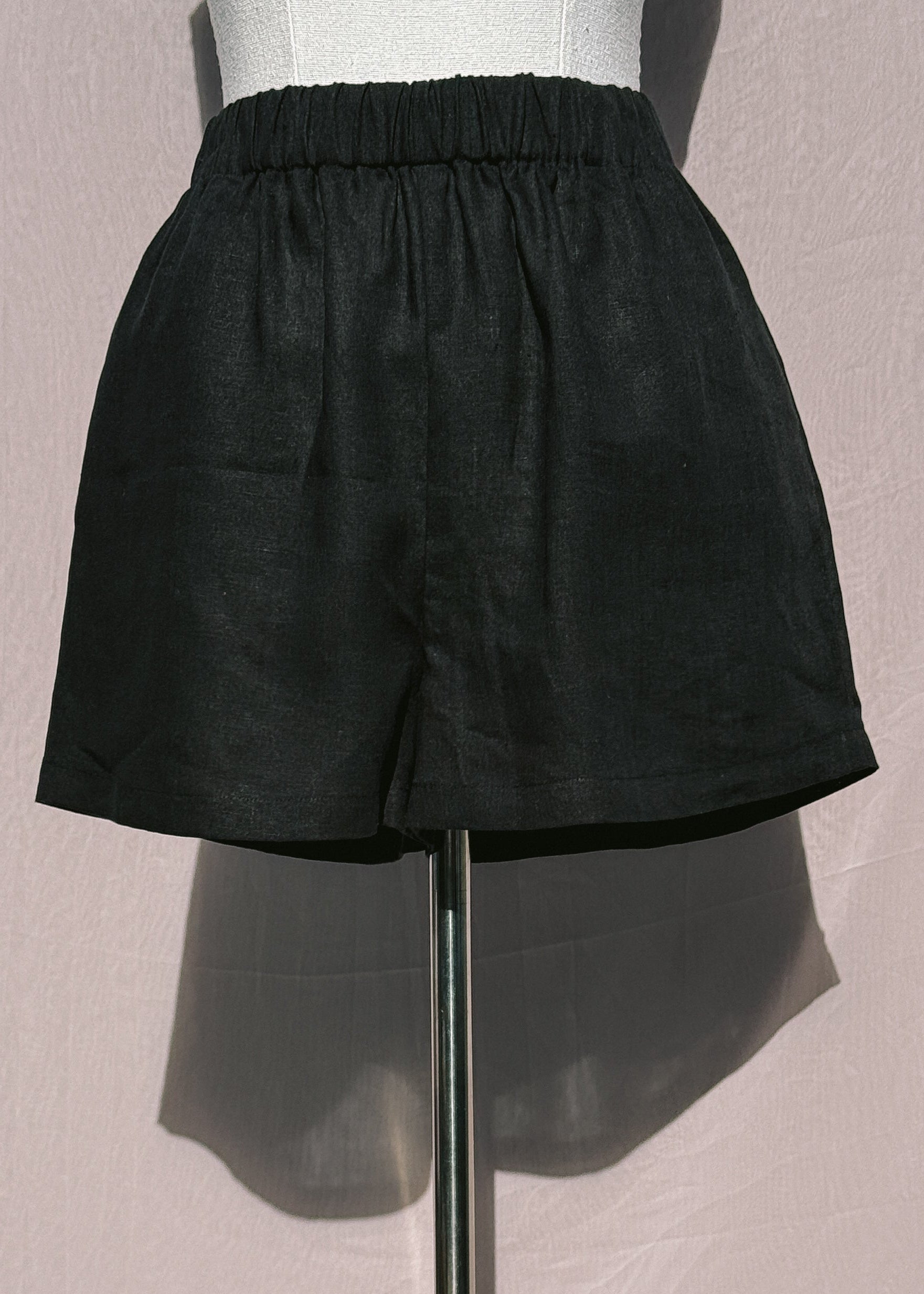 Black linen shorts on a mannequin against a plain background