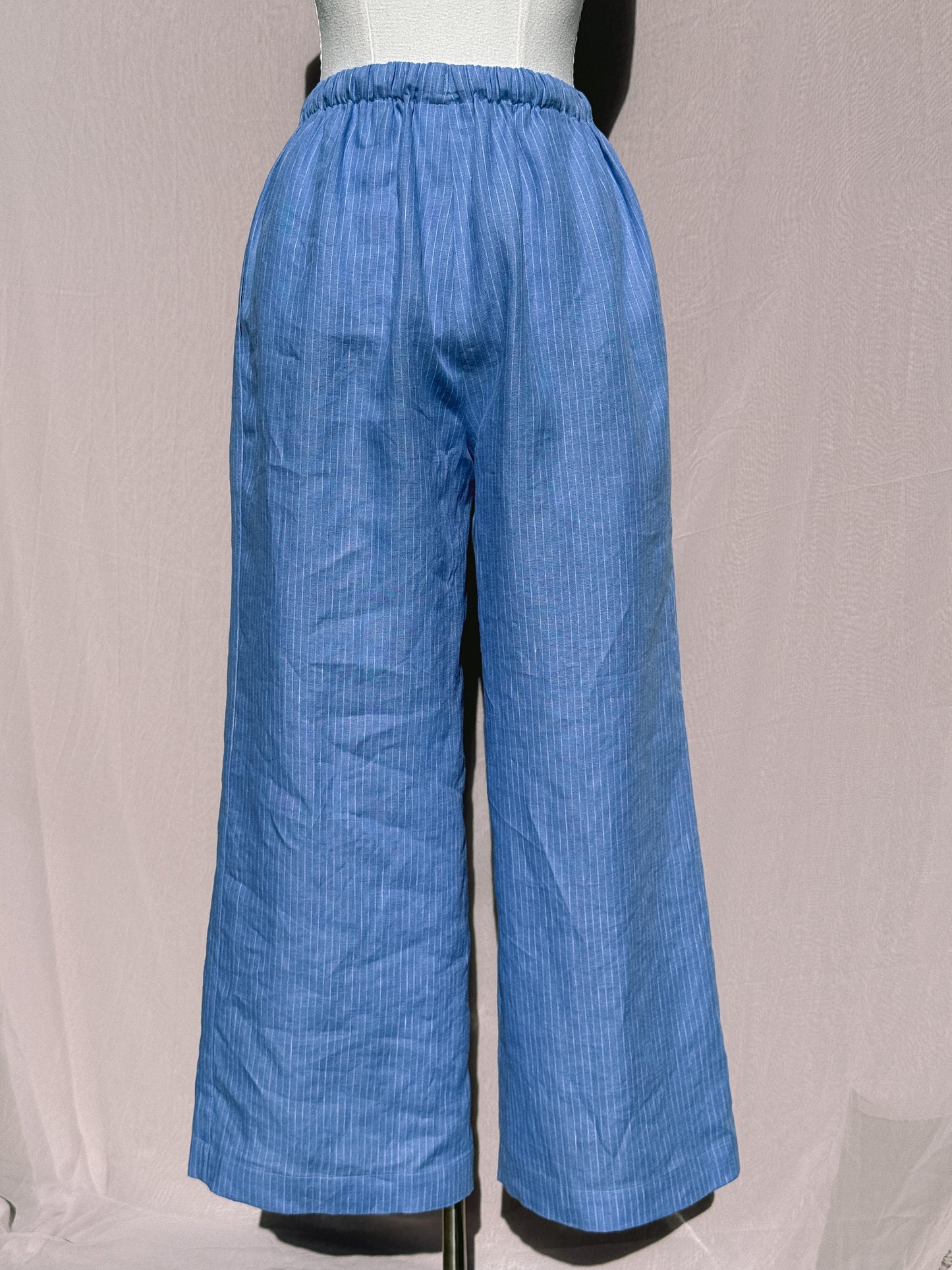 Blue pinstripe wide-leg pants on a mannequin against a plain background