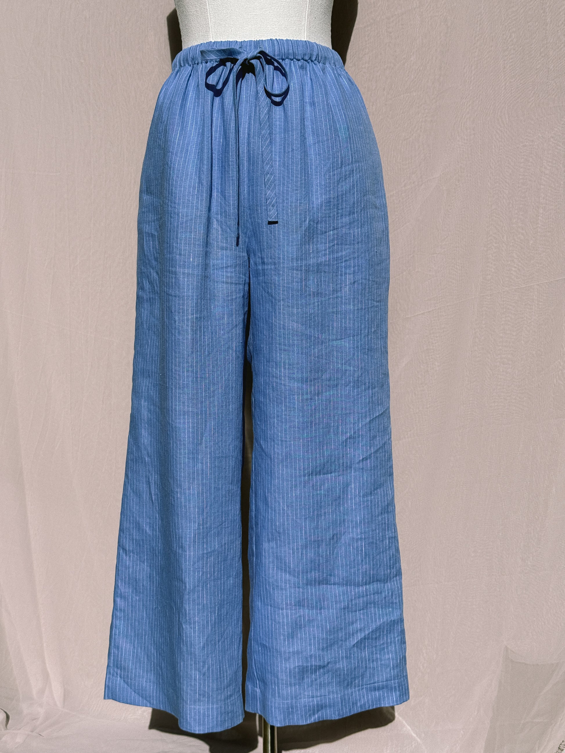 Blue stripe wide-leg pants with waist tie on a mannequin against a plain background