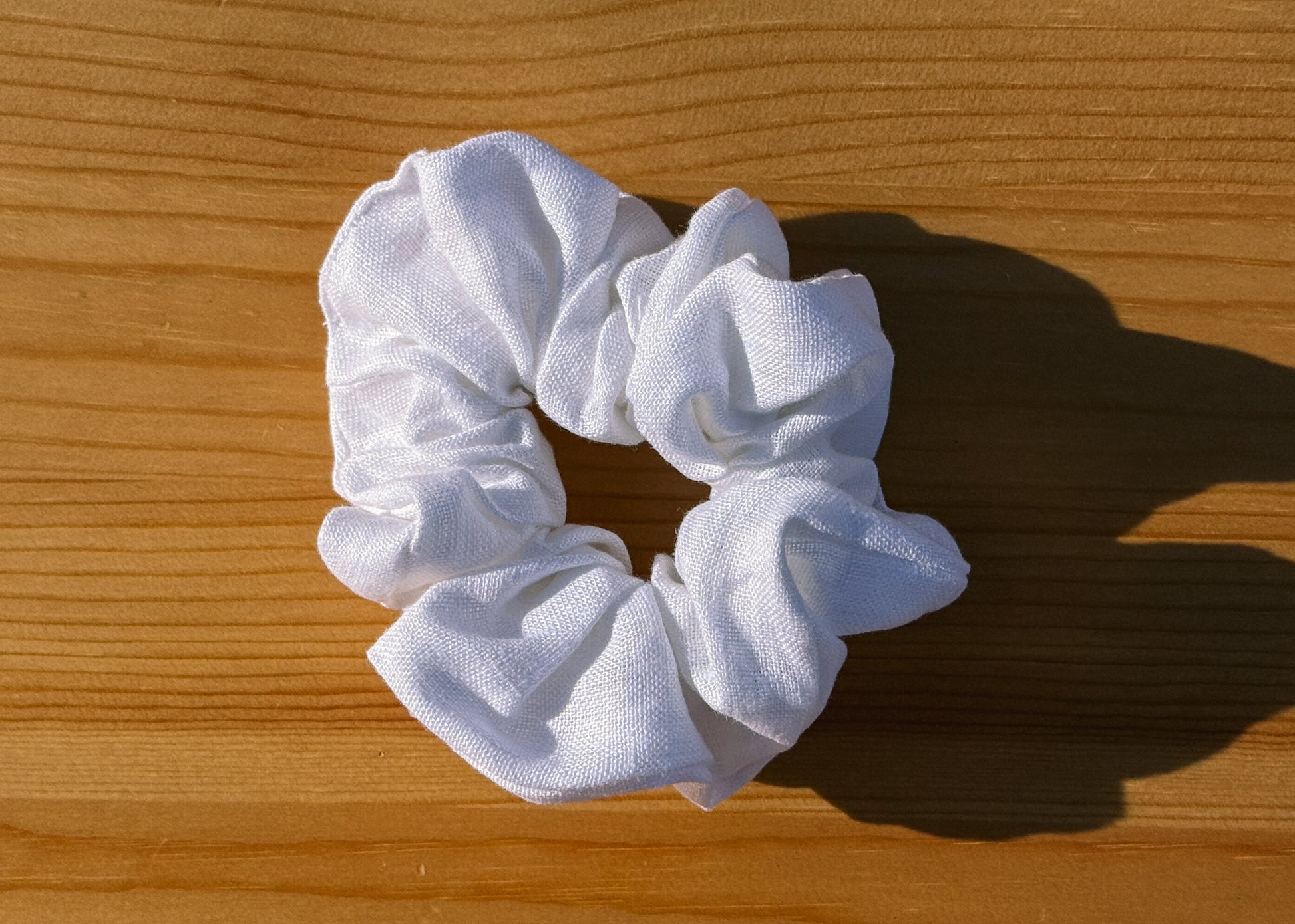 White scrunchie on a wooden surface
