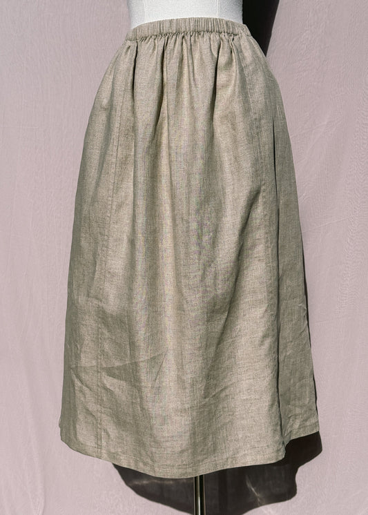 Beige linen skirt with welt seams on a mannequin against a plain background