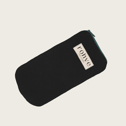 Black pouch with a brand label on a light beige background