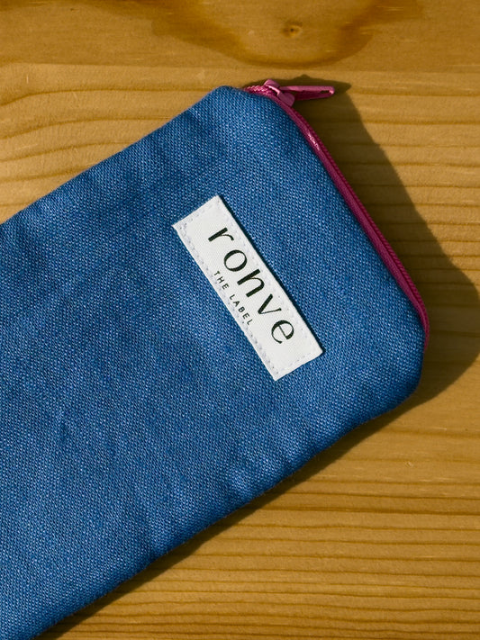 Blue striped pouch with a brand label on a wooden background