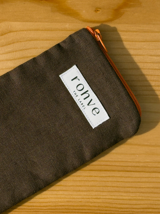 Brown pouch with a brand label on a wooden background