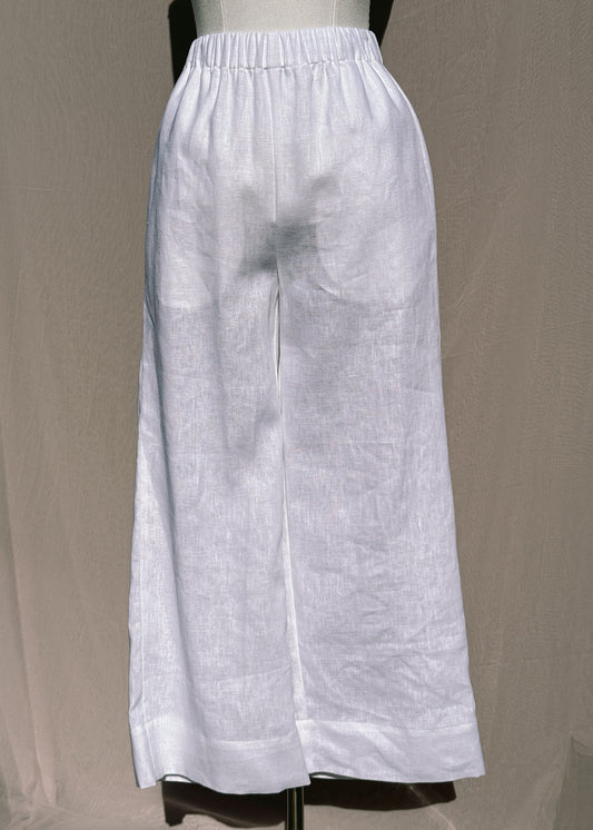 White wide-leg pants on a mannequin against a beige background