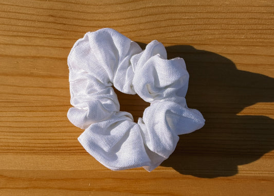 White scrunchie on a wooden surface